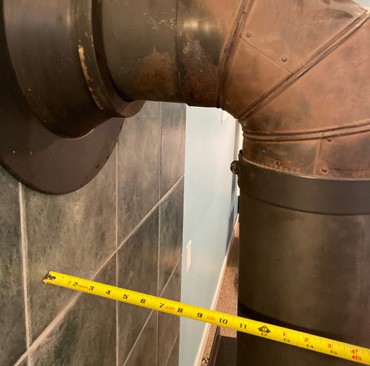 Sewer pipe inspection with measuring tape for WETT certification.