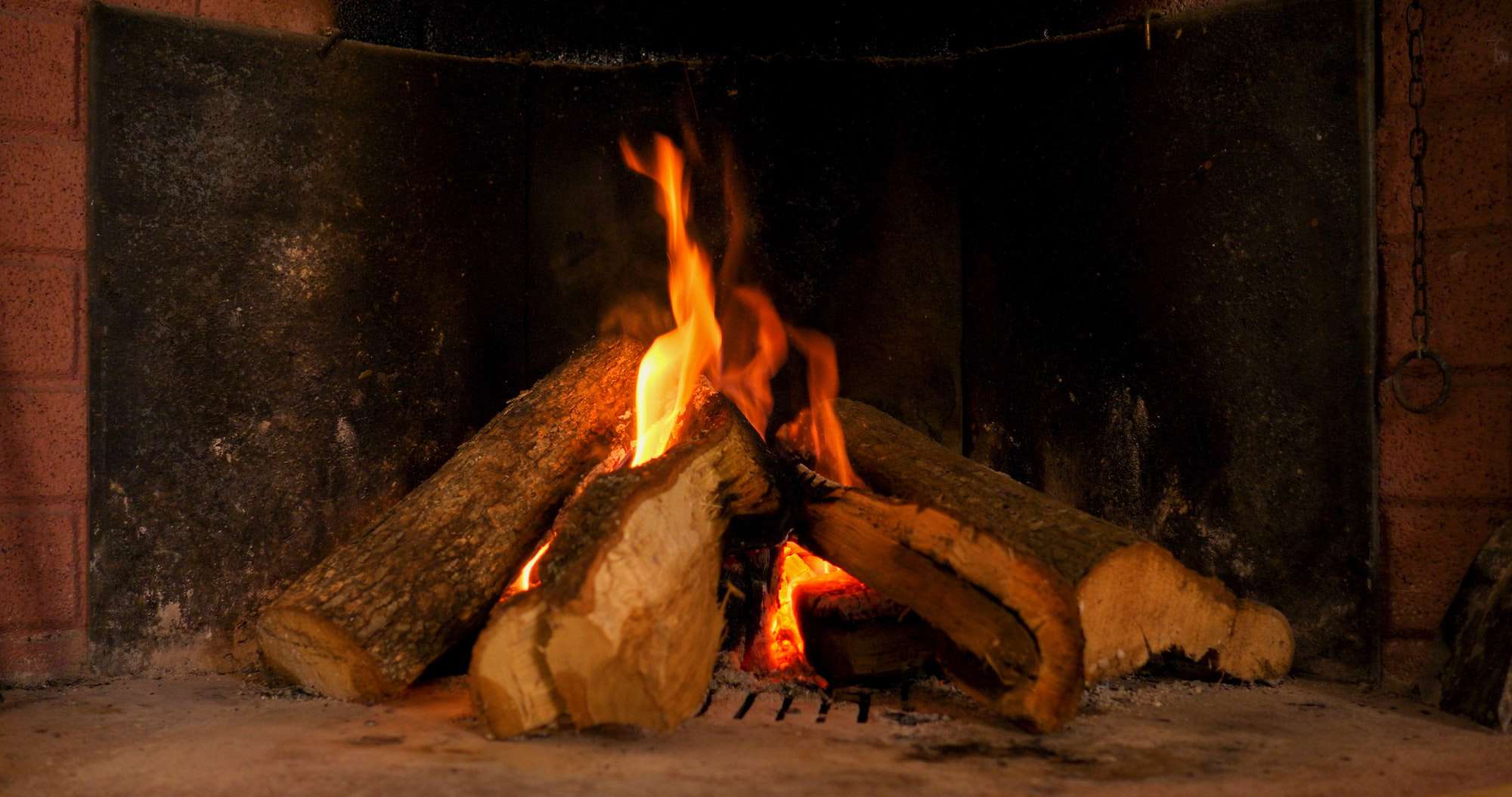 A warm fire in a chimney. Burning wood in the fireplace and the flames
