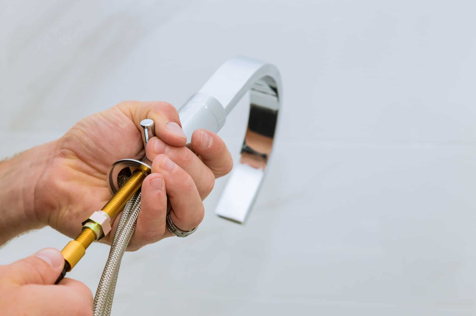 Installing water faucet in the bathroom plumber at work in a bathroom