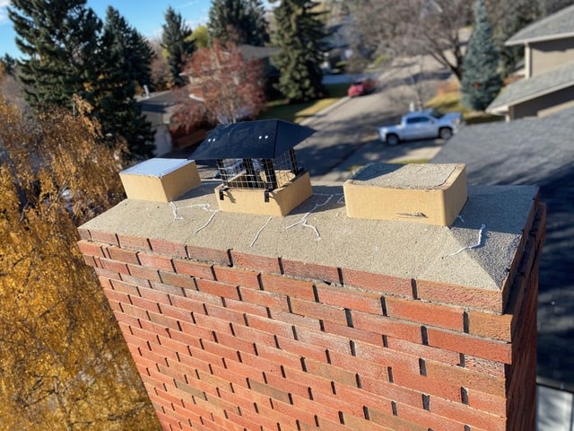 Chimney cap installation on brick chimney for safety and weather protection.