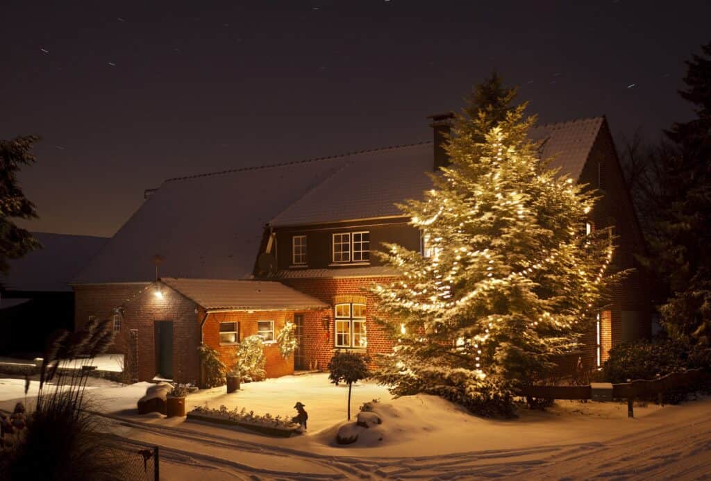 Winter House With Tall Christmas Tree At Night
