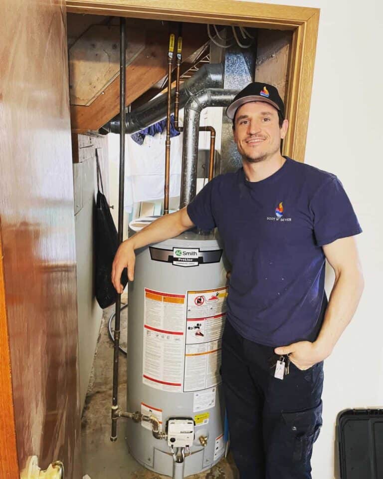 Plumbing technician from Soot N' Sewer with water heater in service area.