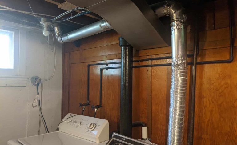 Newly rerouted dryer vent pipes in basement for improved airflow.